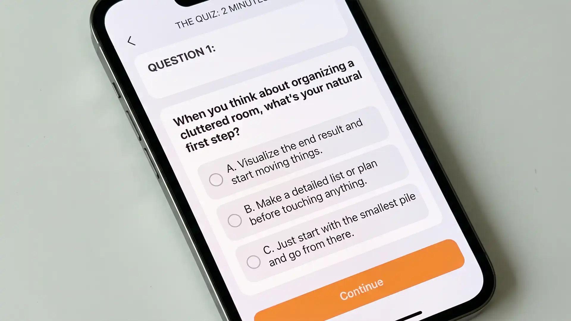 Woman looking at a phone quiz in a quiet kitchen with soft daylight